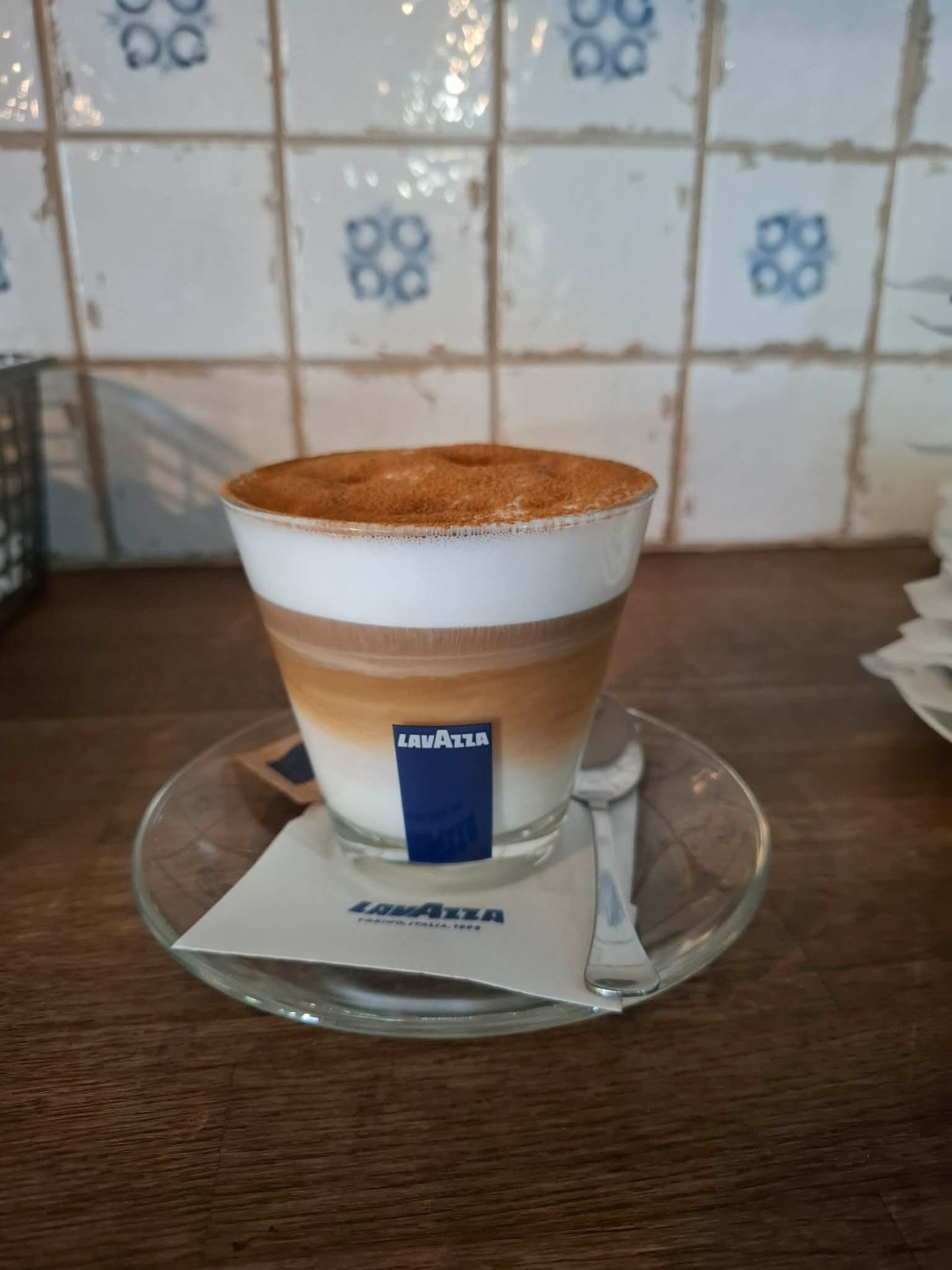 Cappuccino Lavazza v pohári na drevenom stole